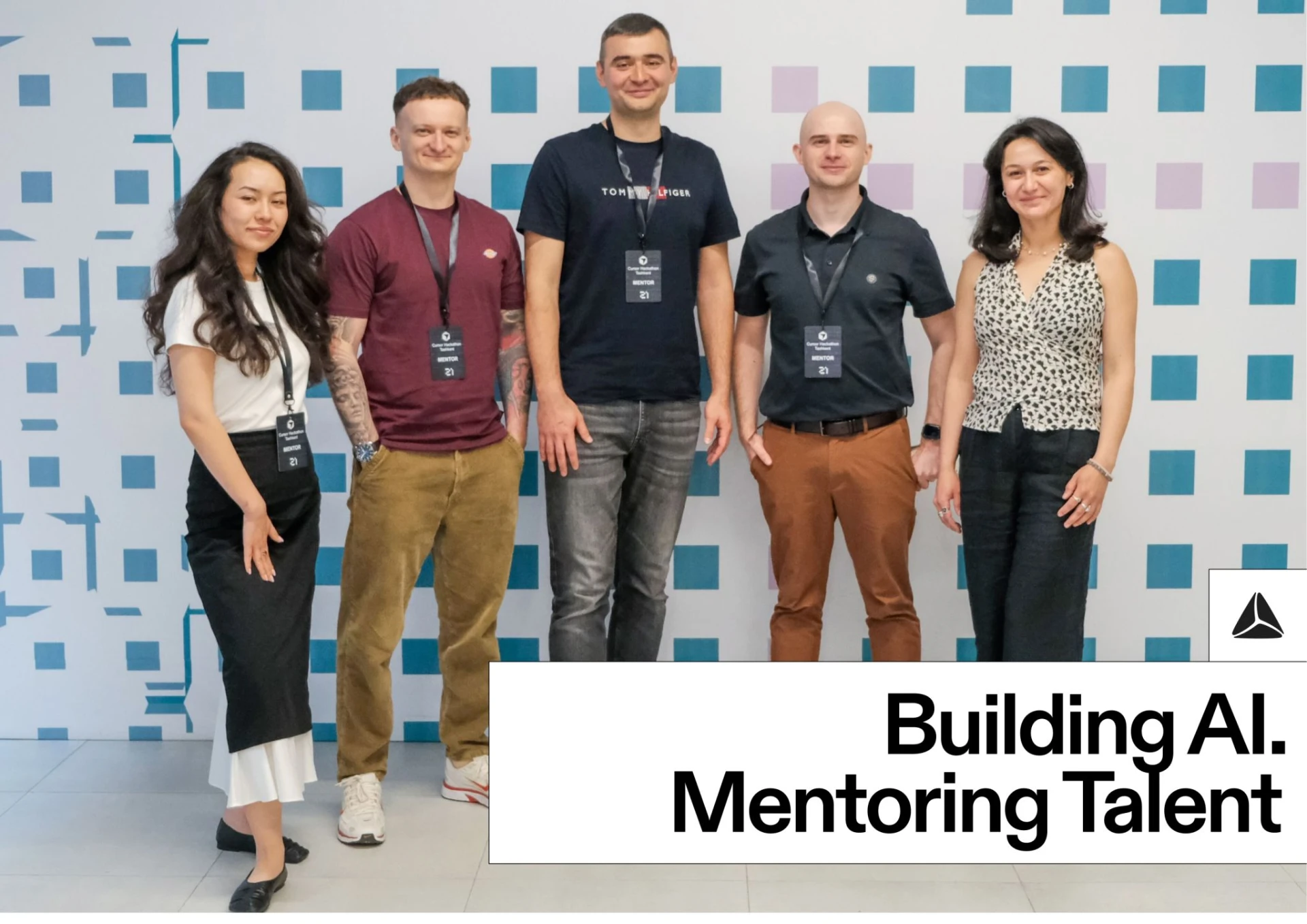 Hackathon mentors standing in front of a patterned wall